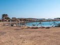 An empty, abandoned beach against the backdrop of a pier, palm trees and a sunny sky Royalty Free Stock Photo