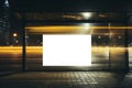 Empty advertising billboard at a city bus stop in the nighttime, illuminated against a busy road backdrop.