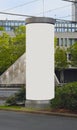 Empty advertising pillar in a city with grey free copy space, promotion mock up. Blank advertising panel