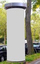 Empty advertising pillar in a city with white free copy space, promotion mock up. Blank advertising panel