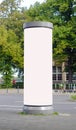 Empty advertising pillar in a city with white free copy space, promotion mock up. Blank advertising panel