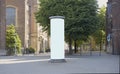 Empty advertising pillar with historic buildings, free copy space Royalty Free Stock Photo