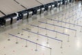 Empty airport check-in counter hall with crowd control barriers Royalty Free Stock Photo