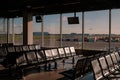 Empty airport lounge with runway view windows