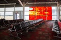 Empty airport terminal leather seating with abstract fire window art and an exit door