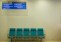 Empty airport terminal waiting area with chairs