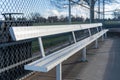 An empty aluminum bench in a baseball dugout at a public park. Royalty Free Stock Photo