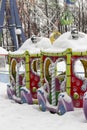 An empty amusement park in winter, a multi-colored carousel steam engine under a thick layer of snow. City leisure park for Royalty Free Stock Photo