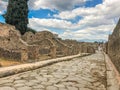 Empty Ancient Roman city of Pompeii under a blue sky with clouds. Panorama of an abandoned street in Pompeii. City ruins Royalty Free Stock Photo