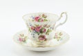 Empty antique cup and saucer with rose decoration isolated