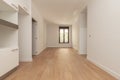 Empty apartment with light wood flooring, long window