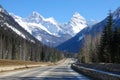 Empty asphalt highway offers a breathtaking view of the snowy mountaintops