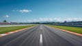 Empty asphalt racetrack stretching far into the distance under a vast bright blue sky with distant mountains visible beyond the Royalty Free Stock Photo