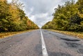 Empty asphalt road through the autumn woods. Autumn scene with road in forest. Beautiful scenic empty road in the fall and woods. Royalty Free Stock Photo