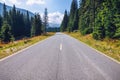 Empty asphalt road with cloudy sky and sunlight in mountains and forest. Transalpina landscape, Romania Royalty Free Stock Photo