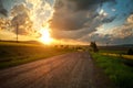 Empty asphalt road among country green yellow fields at sunset sky Royalty Free Stock Photo