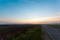 An empty asphalt road through the fields and forest in a thick fog at sunrise Royalty Free Stock Photo