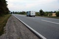 Empty asphalt road and floral field of different grass and flowers in evening time Royalty Free Stock Photo