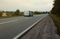 Empty asphalt road and floral field of different grass and flowers in evening time Royalty Free Stock Photo