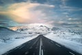 Empty asphalt road leading to snowy mountain range. Nordic winter landscape in Iceland. Clear road for safety transport