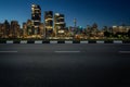 Empty asphalt road with modern cityscape skyline in dusk