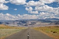 Empty Asphalt road in Mongolia with mongolian town Bayan-Olgii (Bayan-Ulgii or Ulgii) on background