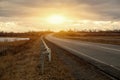 Empty asphalt road with near the lake with cloudy sky in evening light Royalty Free Stock Photo