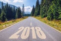 Empty asphalt road and New year 2018 concept. Driving on an empty road in the mountains to upcoming 2018 and leaving behind old 2 Royalty Free Stock Photo