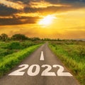 Empty asphalt road and New year 2022 concept. Driving on an empty road to Goals 2022 with sunset Royalty Free Stock Photo