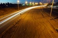 Empty asphalt road during the night with light trails background. Night urban scene with car light trails in the tunnel. Long expo