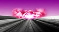 Empty asphalt road stretches into dramatic sunset with pink clouds and dreamy surreal sky creating atmospheric landscape scene Royalty Free Stock Photo