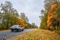 Empty asphalt road through theflower hautumn woods and blurry car. Autumn scene with road in forest Royalty Free Stock Photo