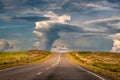 Empty asphalt road to the horizon through autumn steppe under heavy storm clouds at evening time. Royalty Free Stock Photo