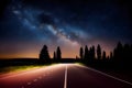 Empty asphalt road between trees under night sky