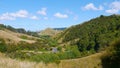 Empty asphalt road winding past tree covered hills in beautiful New Zealand. Royalty Free Stock Photo