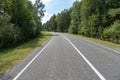 Empty asphalt road through woods and fields. New fresh asphalt pavement away from the city. Development of rural infrastructure. Royalty Free Stock Photo