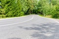 Empty Asphalt winding curve road in a green forest.Landscape with empty asphalt road through woodland in summer day Royalty Free Stock Photo