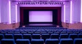Empty Auditorium with Purple Lighting and Blue Seats Royalty Free Stock Photo