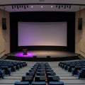 Empty auditorium with stage, podium, and large projection screen Royalty Free Stock Photo
