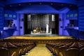 Empty auditorium and stage in the theater. Rehearsal of the play. Artists on stage Royalty Free Stock Photo