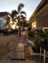 Empty backyard of hotel in Philippines islands. Tropical resort in sunset light. Wooden path in tropical patio. Exotic vacation.