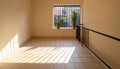 Empty balcony with potted plants and striped sunlight patterns on tiled floor shadows Royalty Free Stock Photo