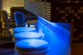 Empty bar stools along bar Illuminated in blue light Royalty Free Stock Photo