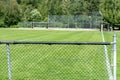 Empty baseball or softball diamond from the back fence and foul line looking towards the grass and trees in Whistler, British Royalty Free Stock Photo