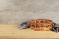 Empty basket with tablecloth on wooden table on old wall background, rustic style, eco concept, kitchen mockup for design and Royalty Free Stock Photo