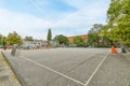 an empty basketball court in a park with trees