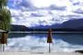 Empty beach bar on a mountain lake, view over the water with cloud reflection Royalty Free Stock Photo