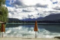 Empty beach bar on a mountain lake, view over the water with cloud reflection Royalty Free Stock Photo