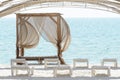 Empty beach beds. Lounge chaise on a sand shore,sun umbrellas omission, empty beach, summer