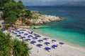 Empty beach - blue deck chairs and umbrellas near sea water Royalty Free Stock Photo